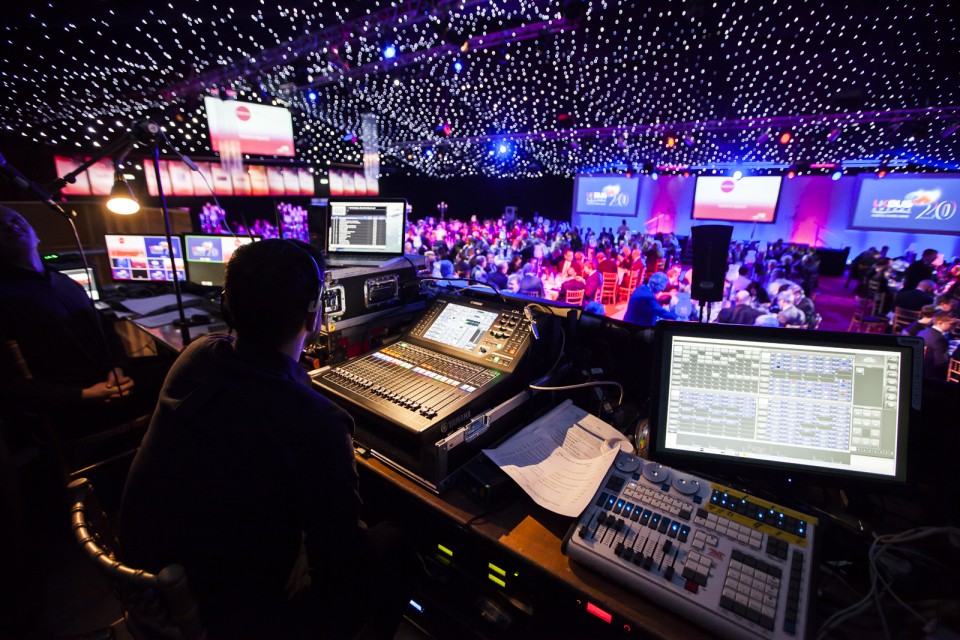 Live event mixer setup surrounded by lighting production